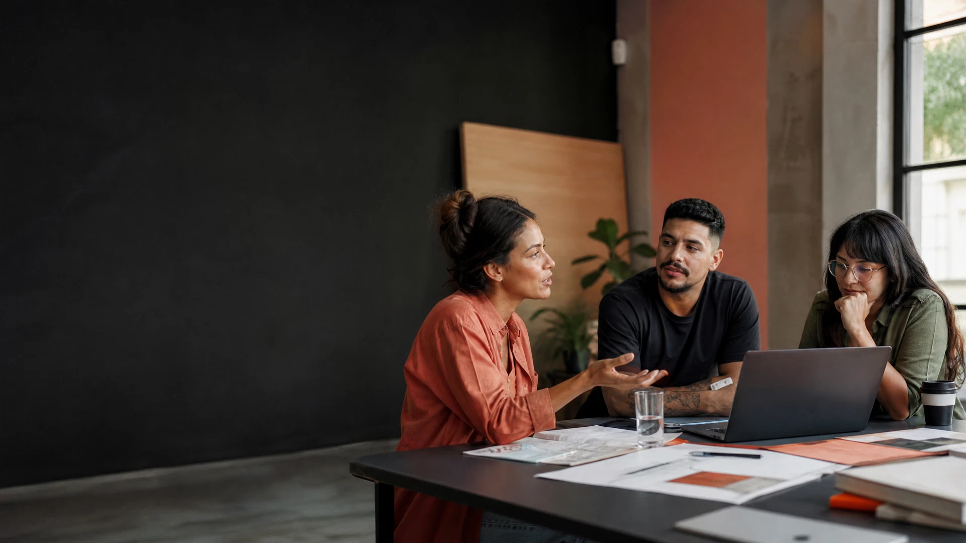 Equipe latina colaborando em um estúdio criativo contemporâneo